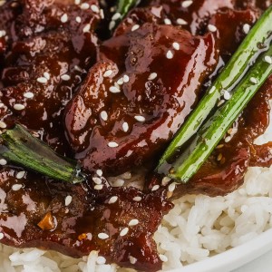 A plate of Mongolian beef and rice with sesame seeds.