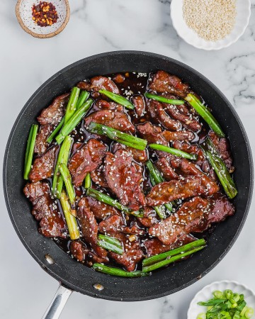 A pan of Mongolian Beef with sauce and vegetables.