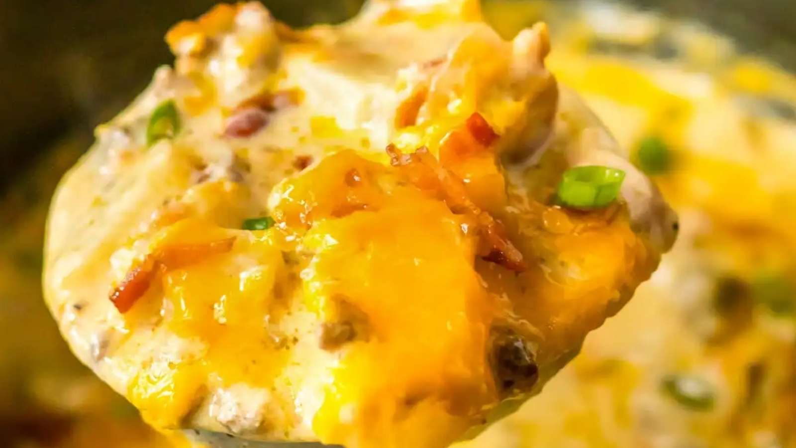 A spoonful of cheesy casserole in a pot.