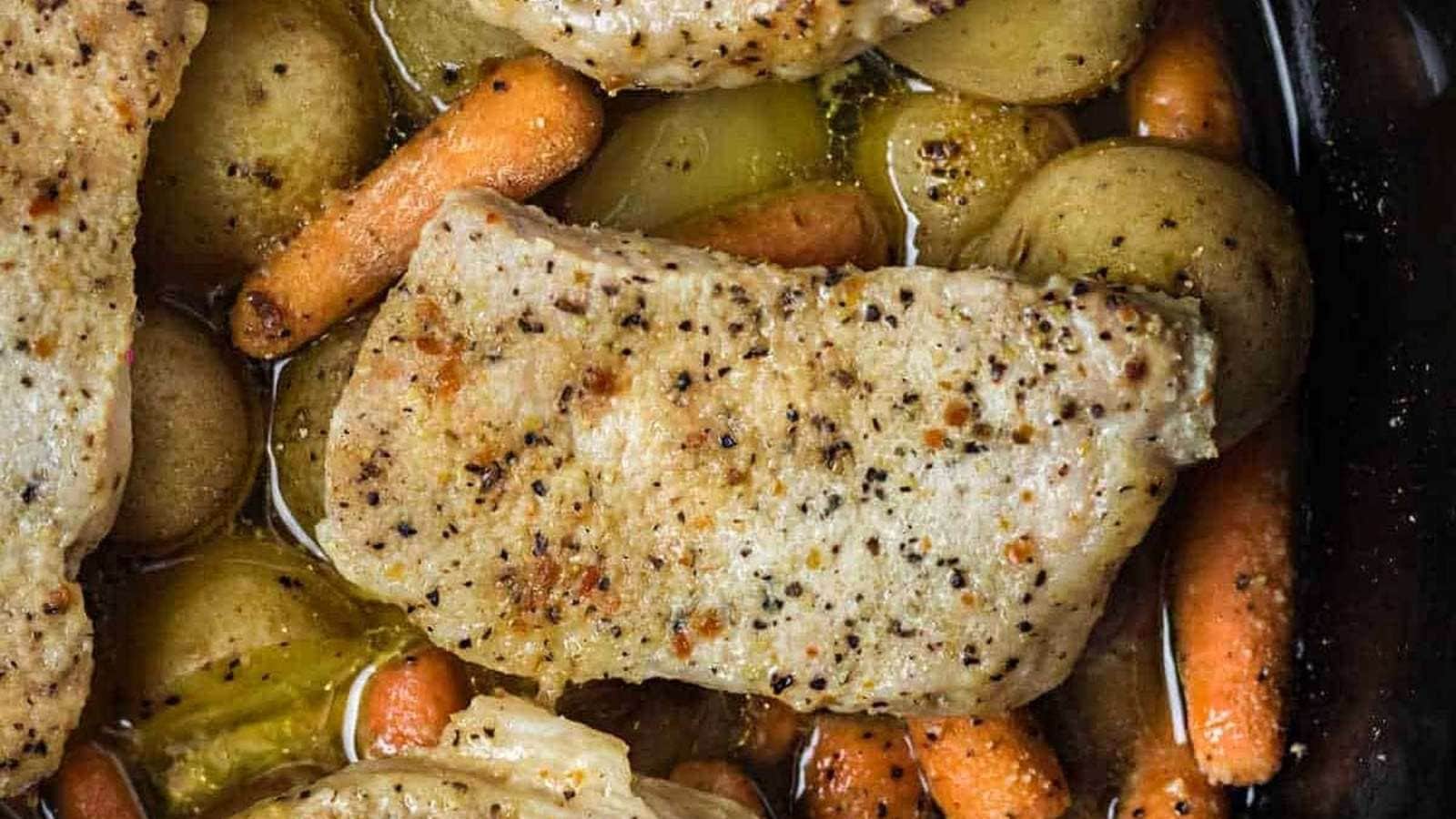 Pork chops in a slow cooker with carrots and potatoes.