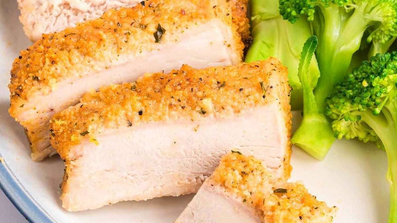 A plate with chicken breasts and broccoli on it.