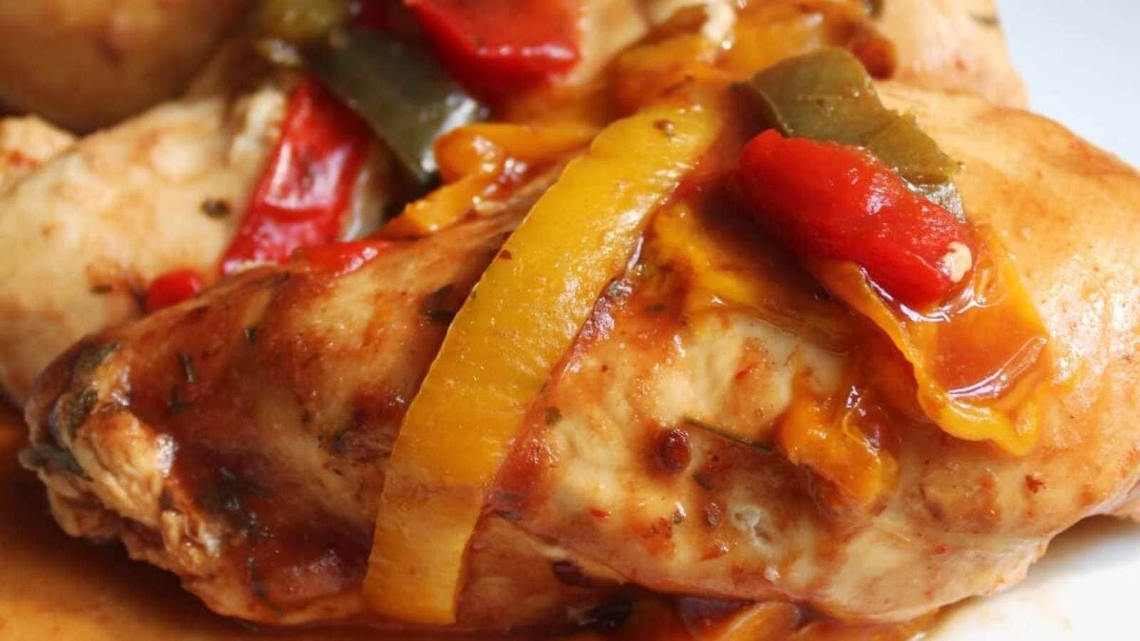 Chicken with peppers and peppers on a plate.