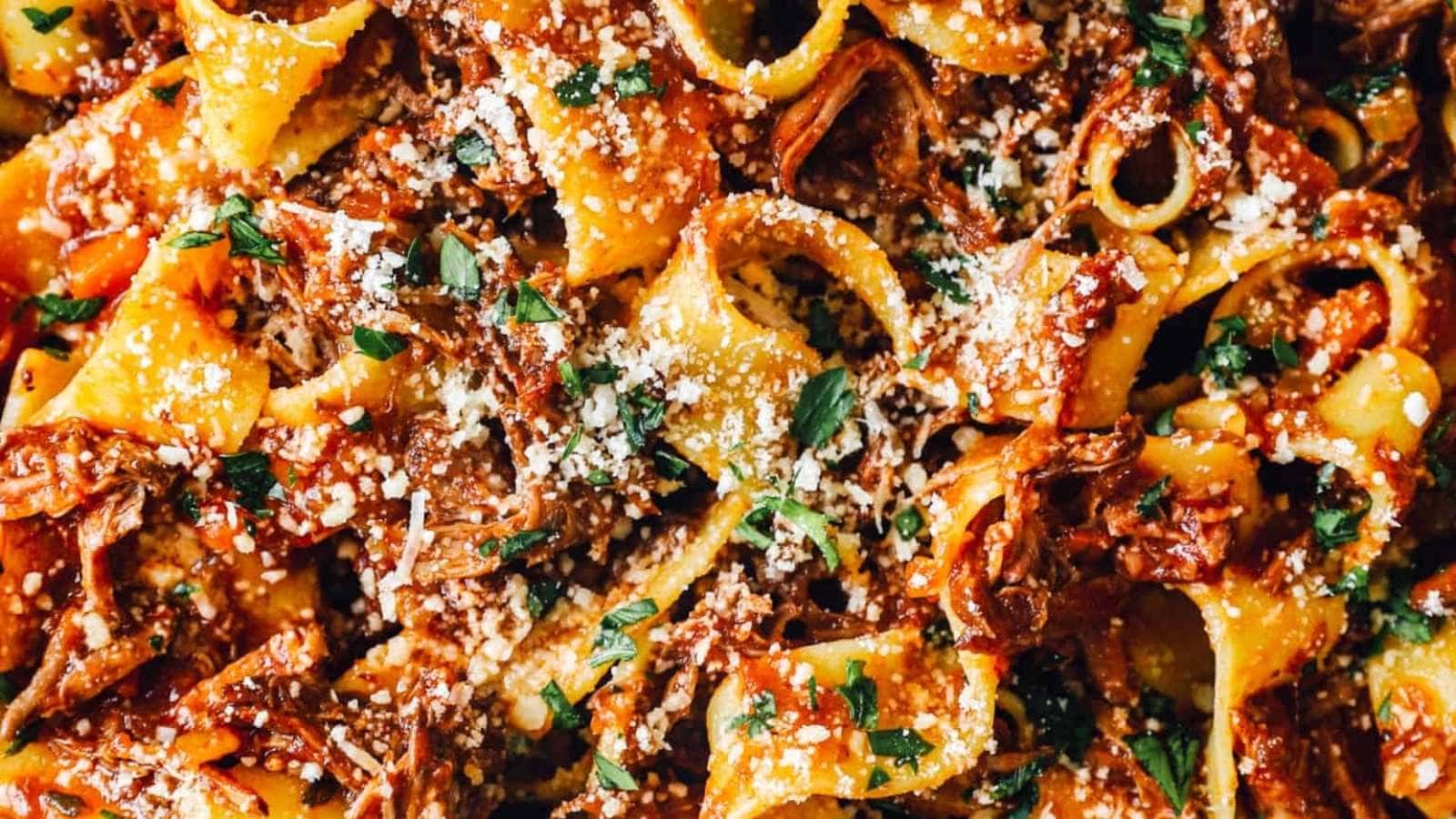 A close up of pasta with meat sauce and parmesan cheese.