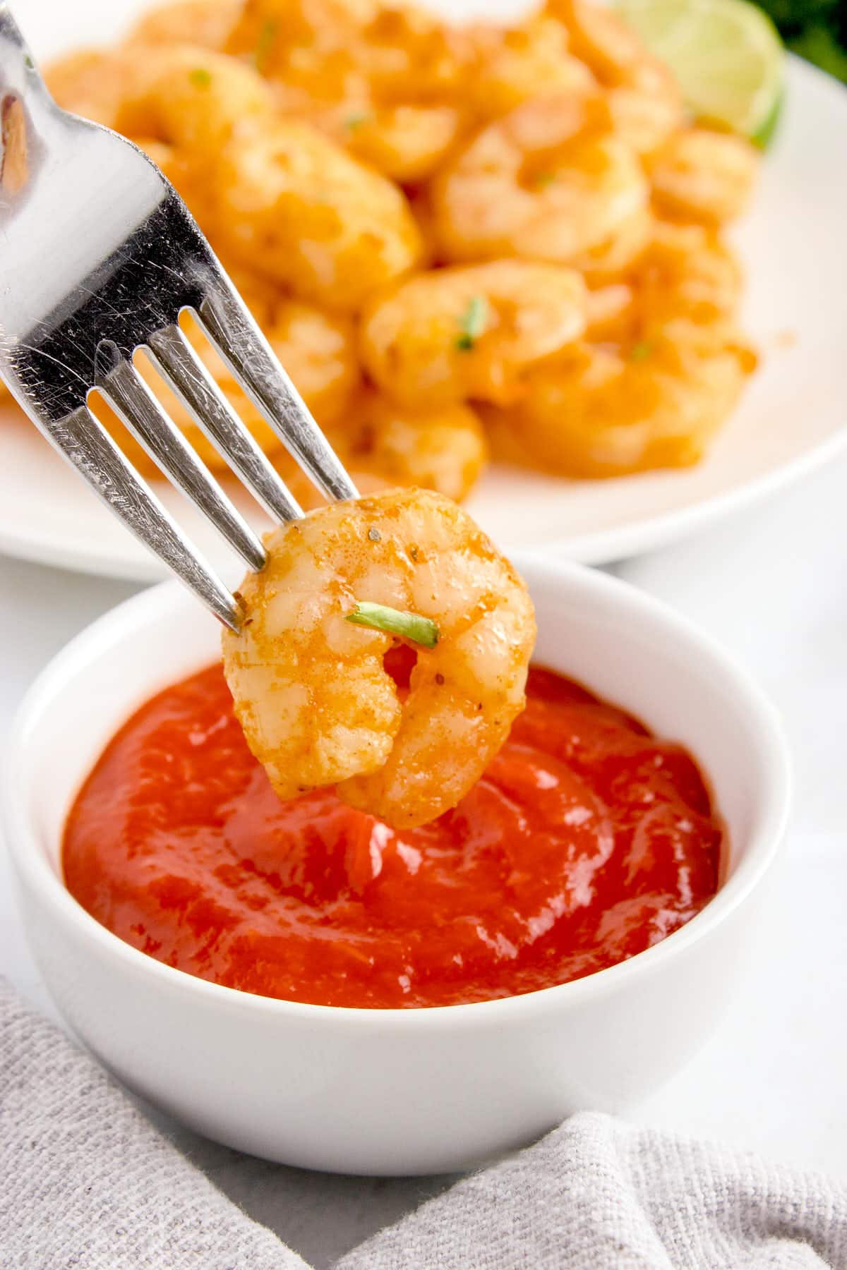 Dipping a shrimp in cocktail sauce.