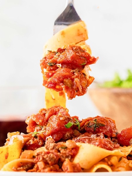 A fork is being used to pick up a plate of pasta.