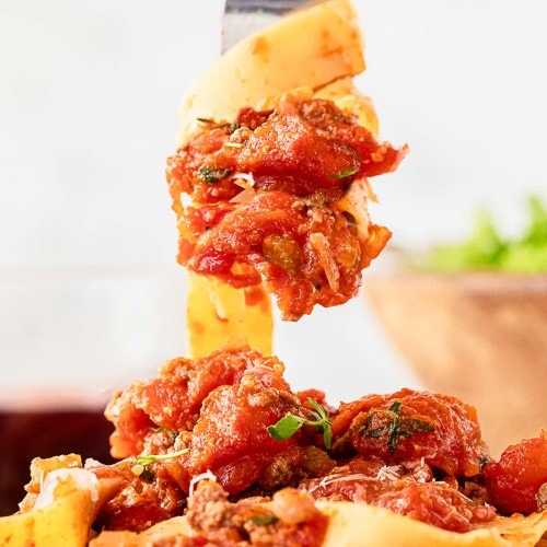 A fork is being used to pick up a plate of pasta.