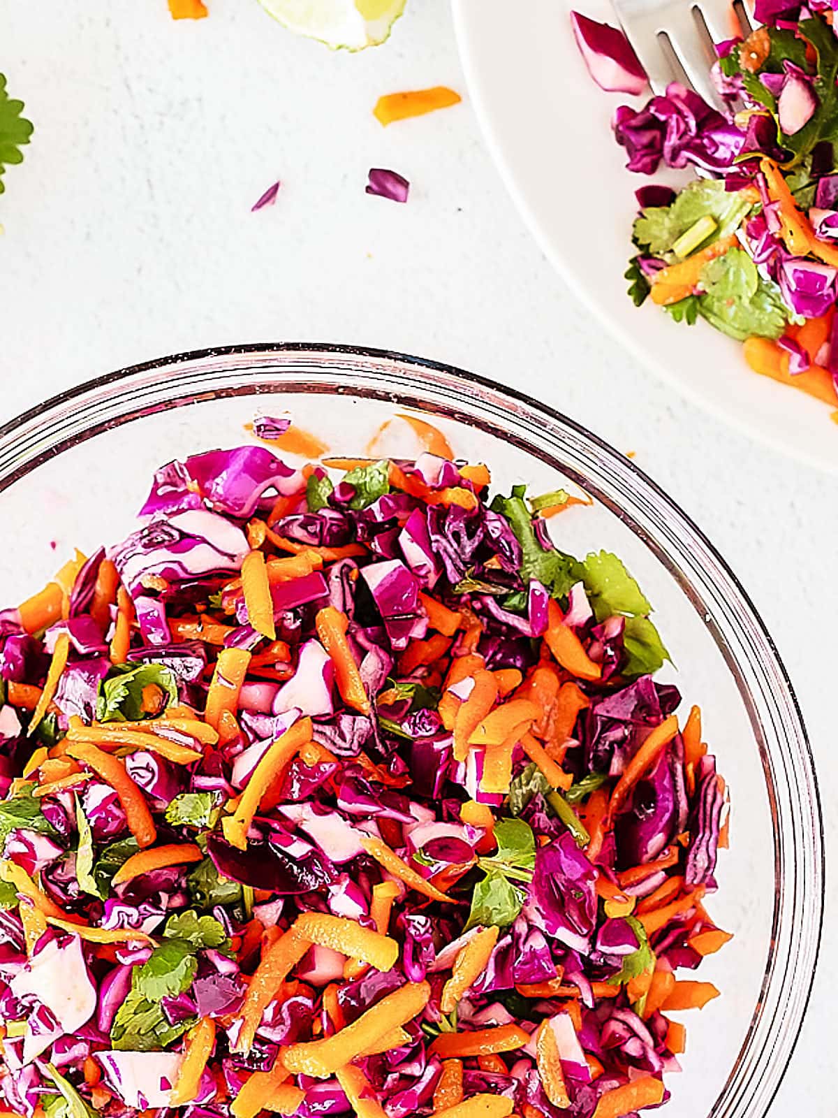 A bowl of red cabbage slaw with lime and cilantro.