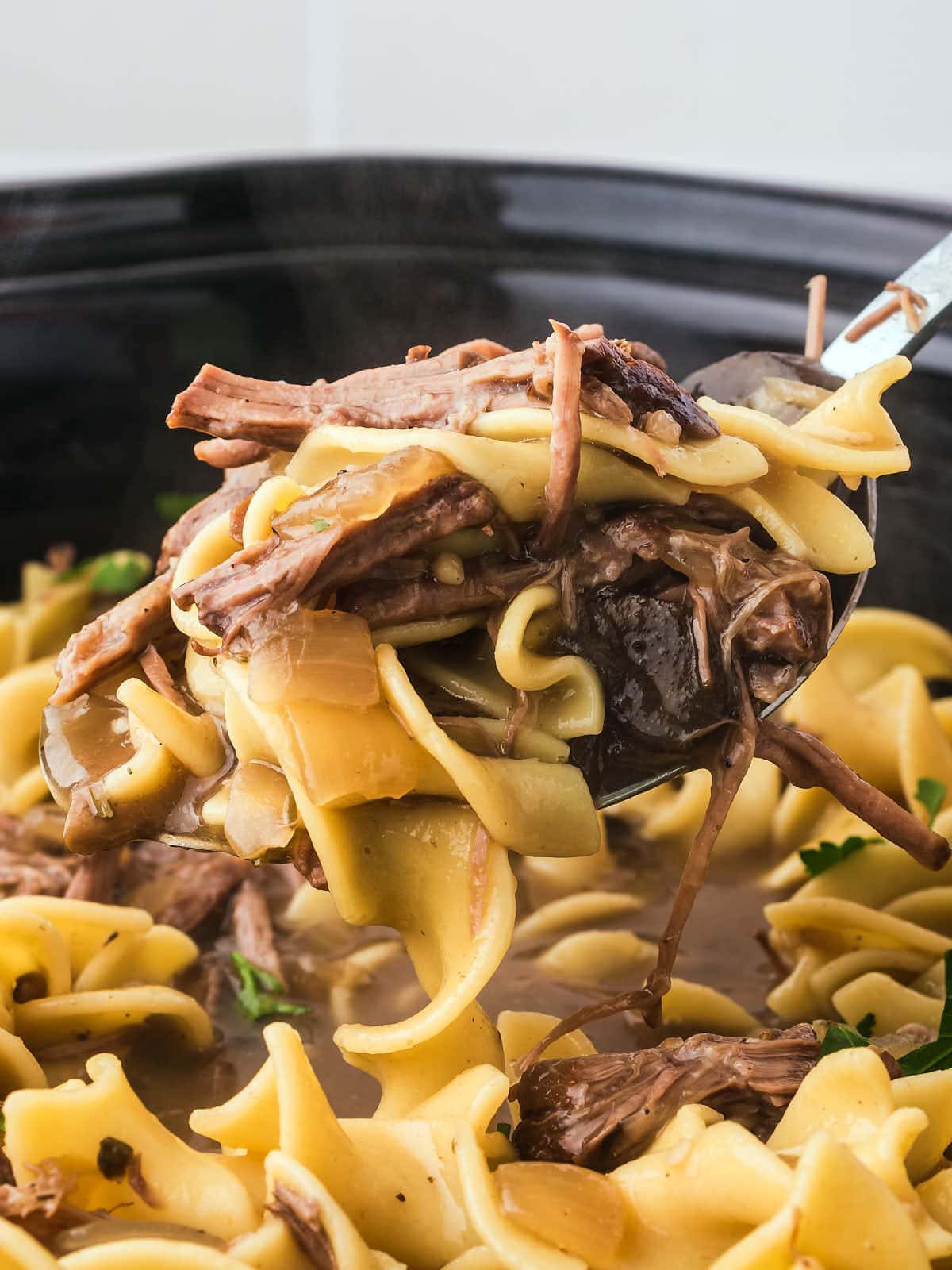 A spoonful of Crock Pot beef and noodles.