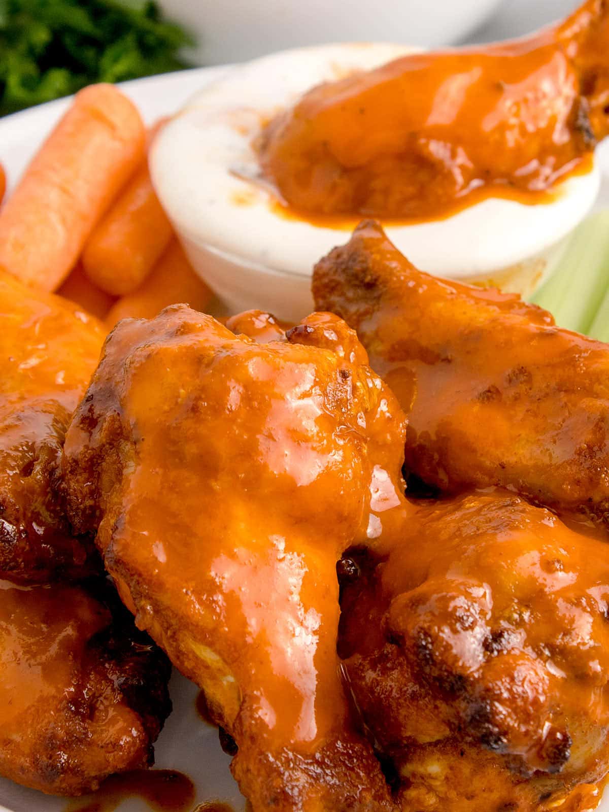 An appetizing plate of buffalo wings served with crisp carrots and celery.