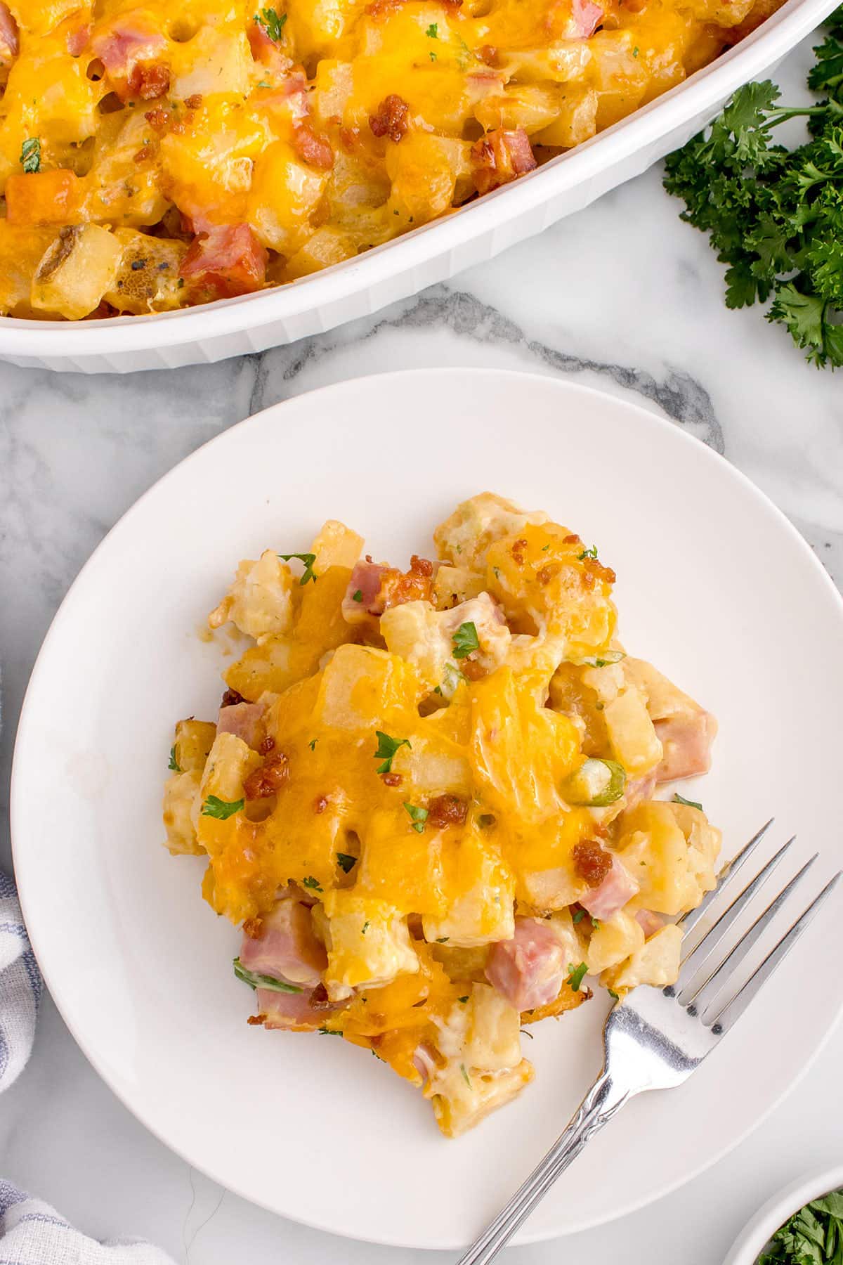 A plate of Ham and Potato Casserole on a marble surface.