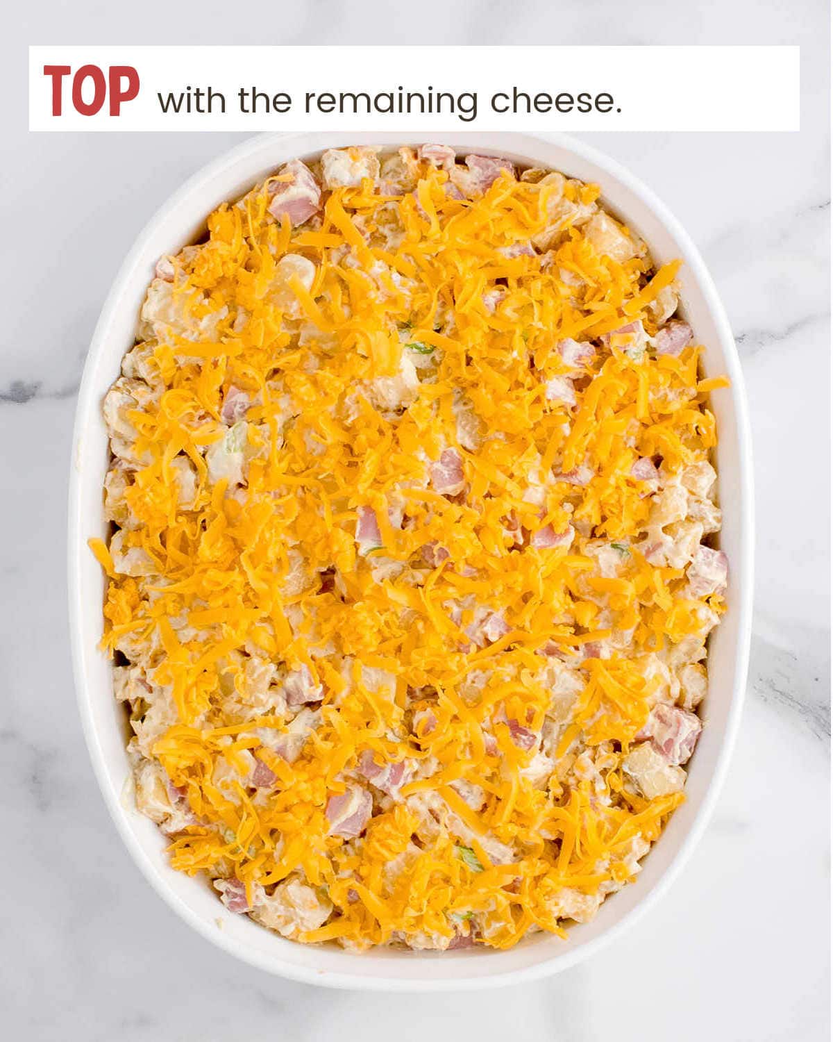 Topping Ham and Potato Casserole with cheddar cheese