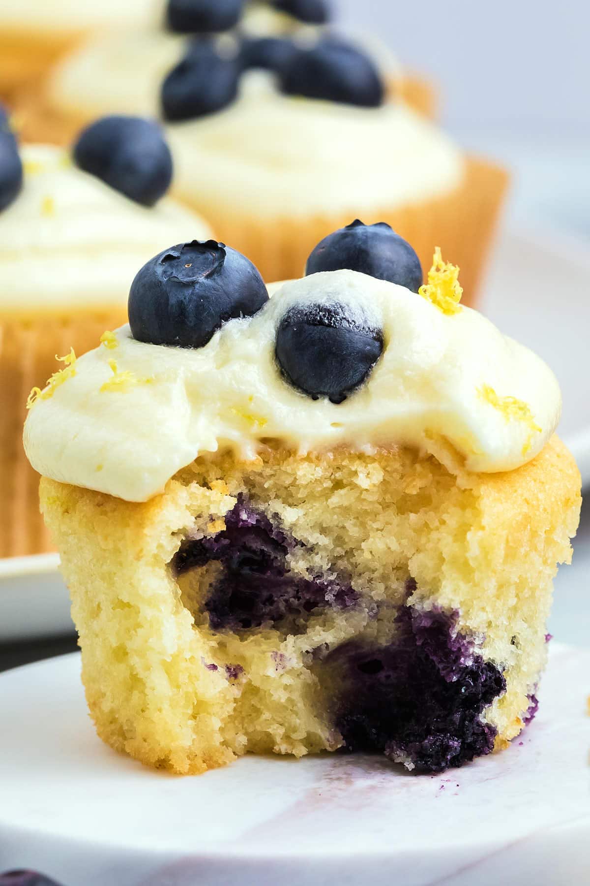 Lemon Blueberry Cupcakes with a bite taken out of them.