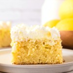A Lemon Poke Cake with whipped cream on top.