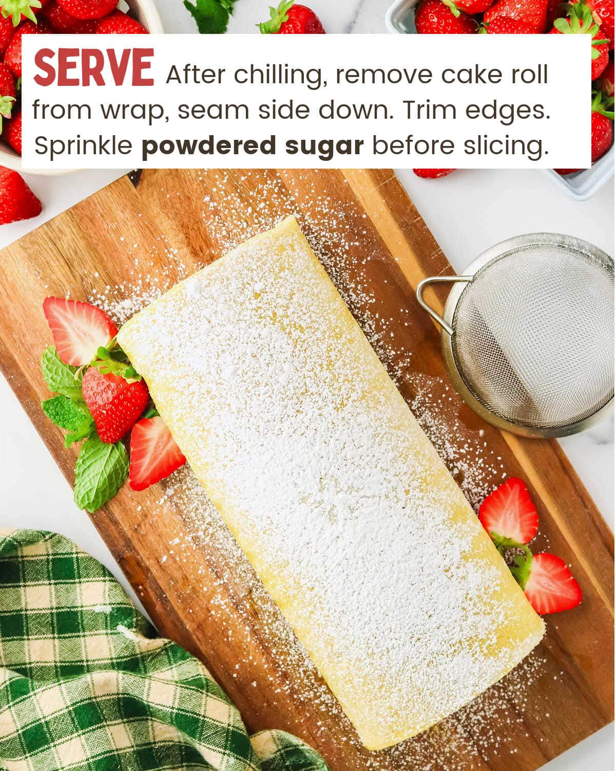 A Strawberry Shortcake Roll with strawberries and sugar on a cutting board.