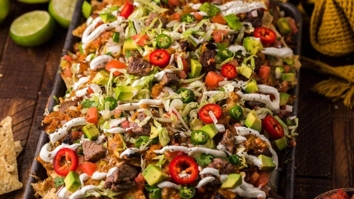 Mexican nachos on a tray with toppings.