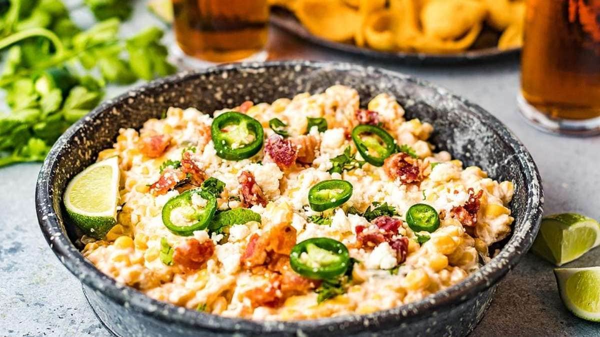 A bowl of nachos with cheese, bacon and jalapenos.