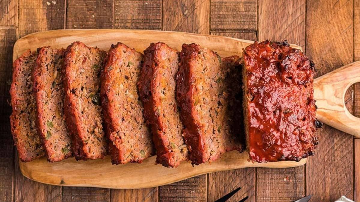 Sliced meatloaf on a wooden cutting board.