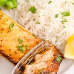 Air Fryer Lemon Pepper Salmon served on a white plate with rice.