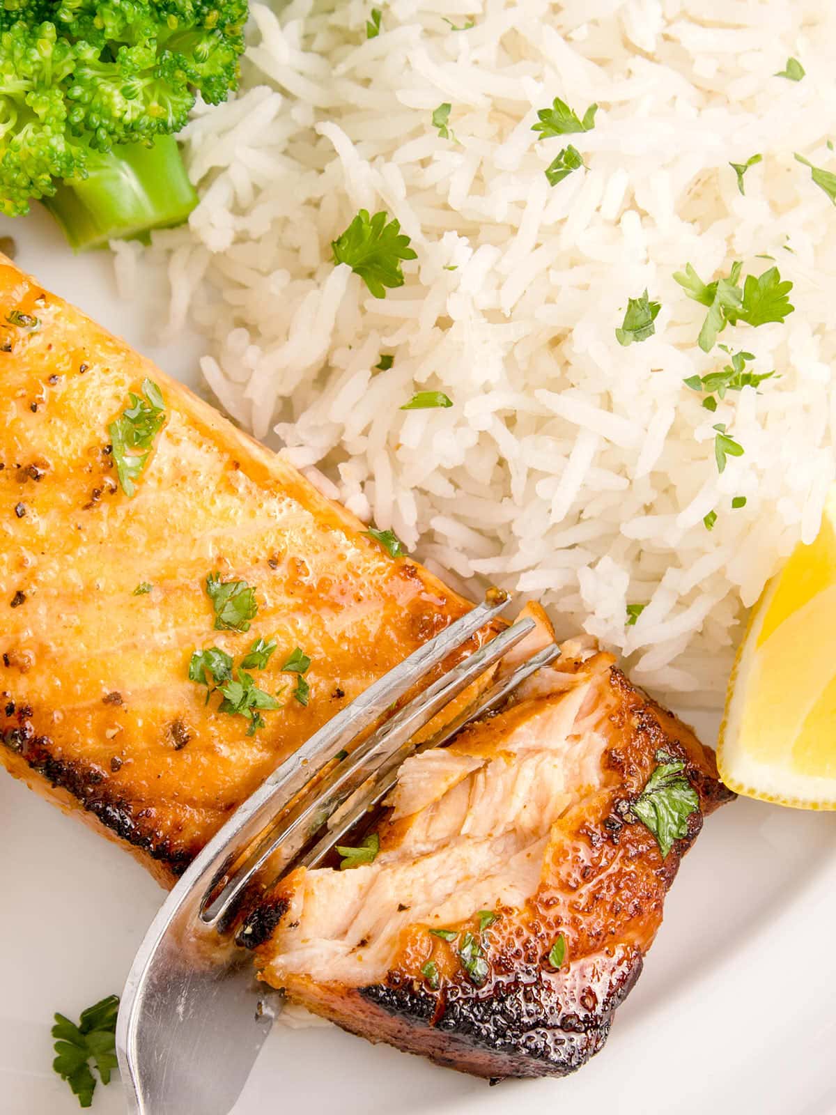 Air Fryer Lemon Pepper Salmon served on a white plate with rice.