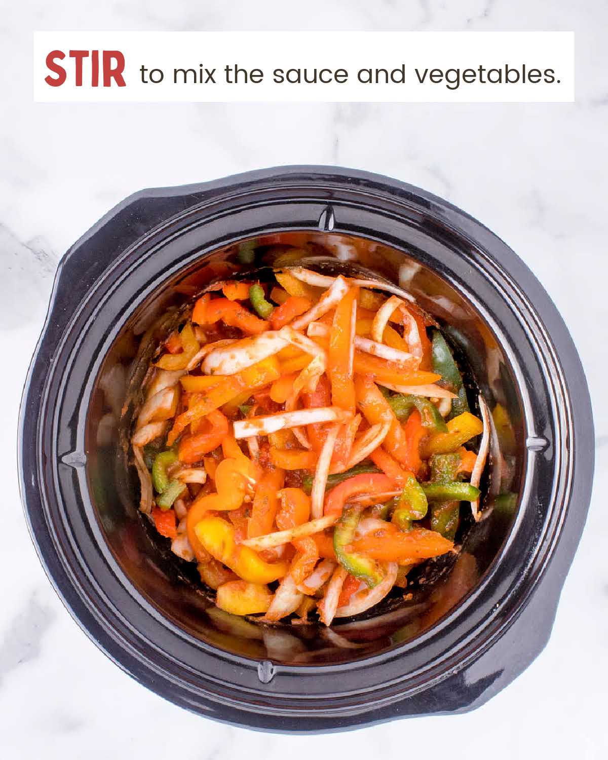 Sliced onions and bell peppers mixed with marinara sauce in a crockpot.