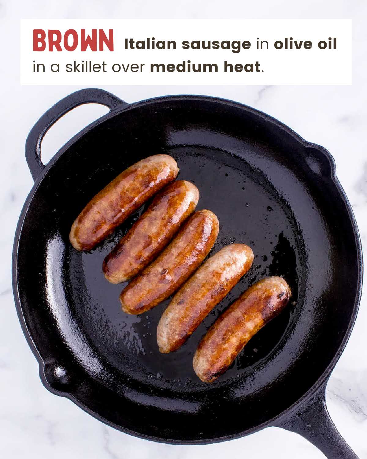 Sausage links browning in a skillet.