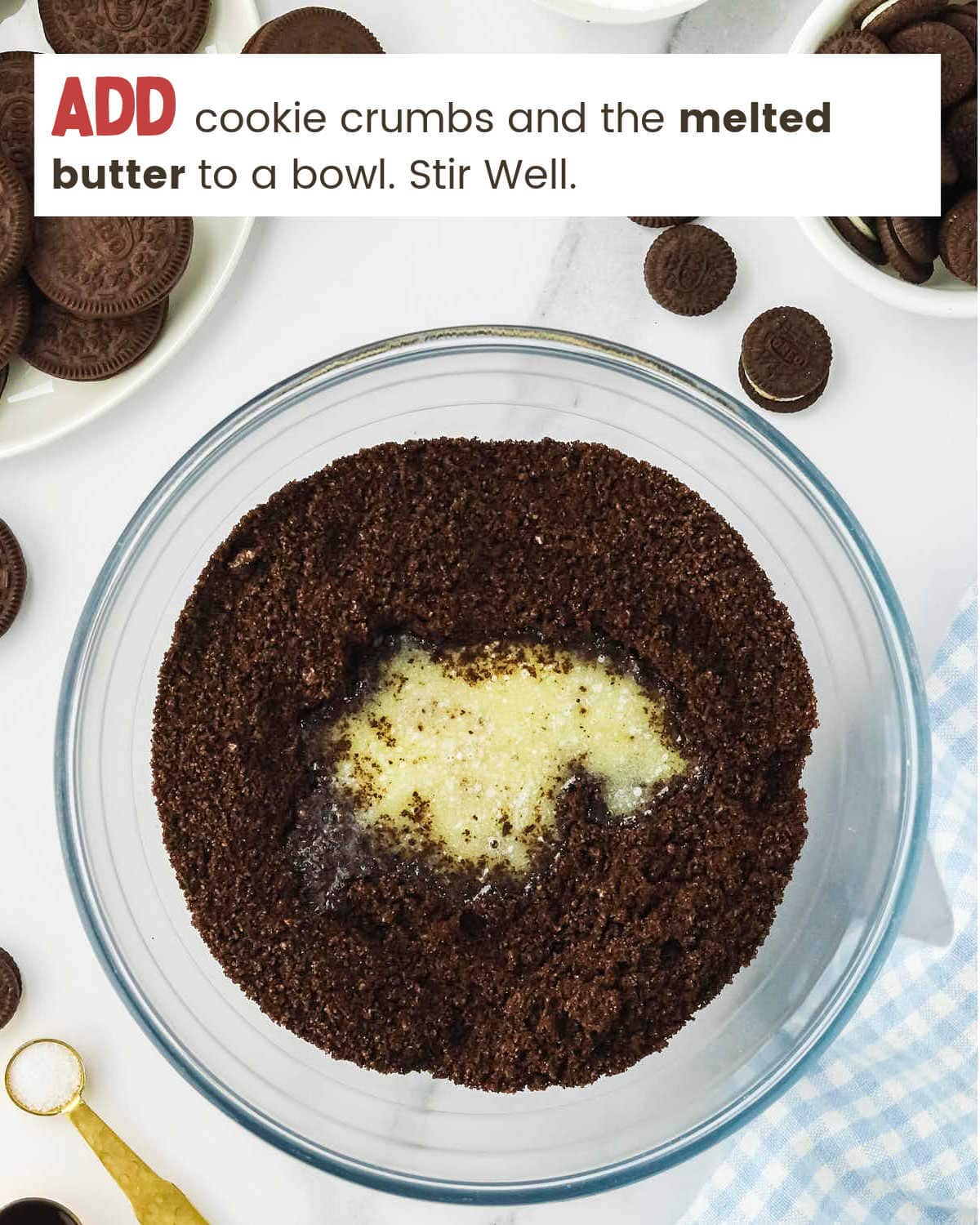 Melted butter and ground Oreos in a glass bowl.