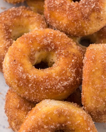 A pile of Air Fryer Donuts rolled in Cinnamon Sugar.