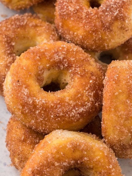 A pile of Air Fryer Donuts rolled in Cinnamon Sugar.