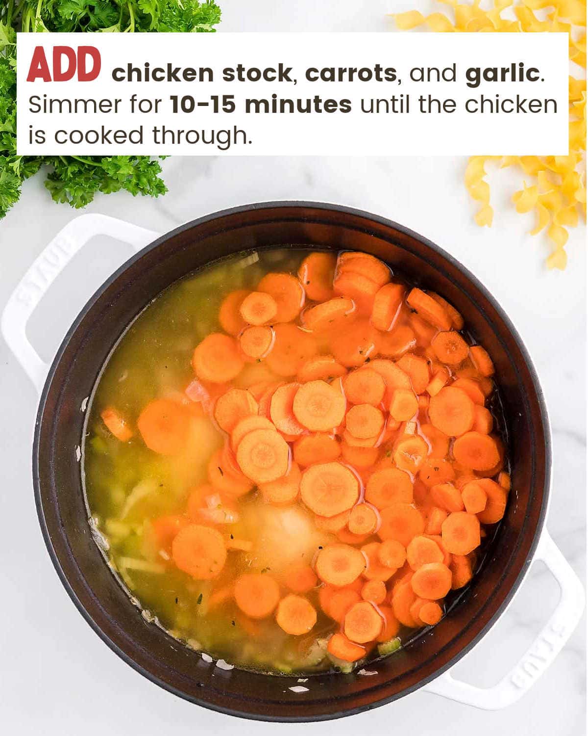 Simmering carrots, celery and chicken in a Dutch oven.