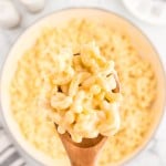 Top-down view of a wooden spoon filled with Gouda Mac and Cheese.