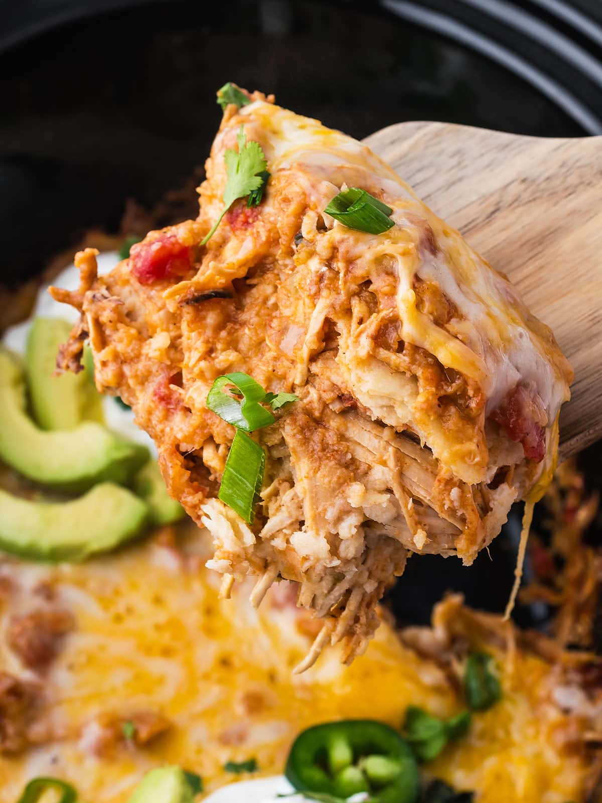 Scooping out a serving of Chicken Enchilada out of a slow cooker.