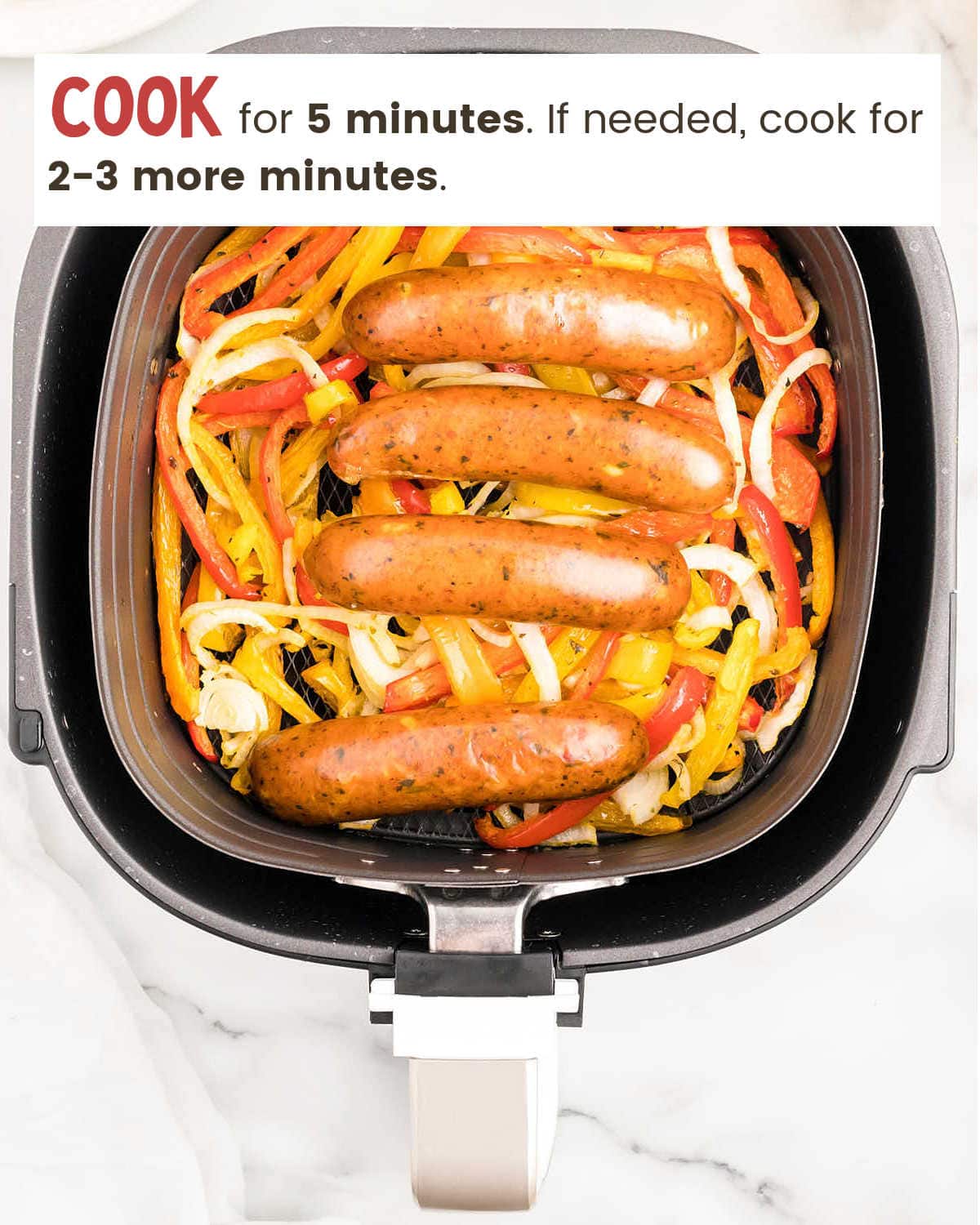 Cooked Air Fryer Chicken Sausage and Peppers in air fryer.