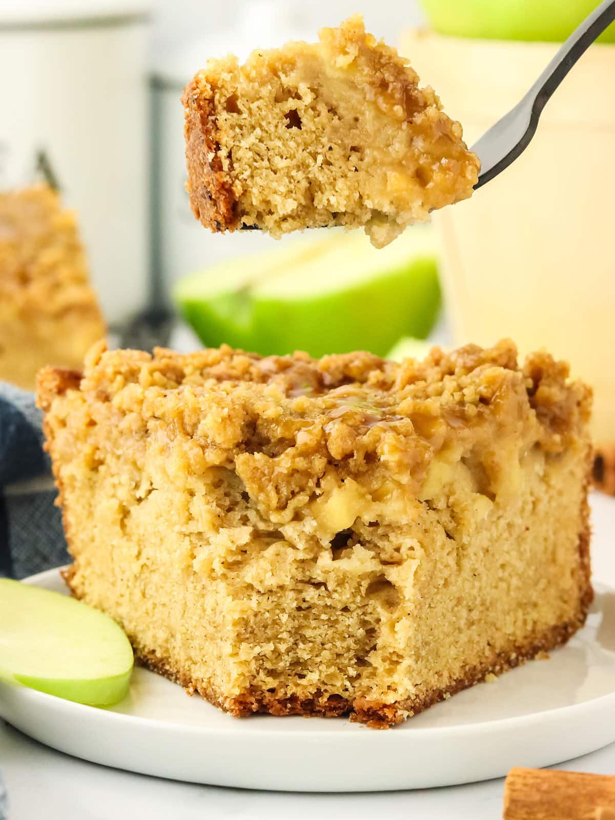 A piece of Apple Crumb Cake with a fork.
