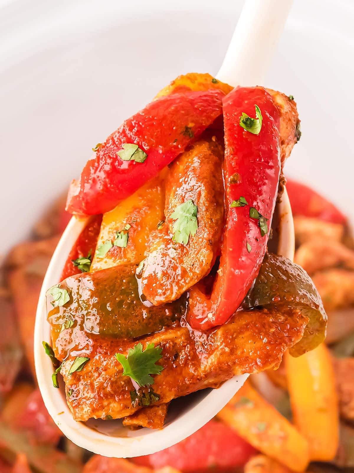 Crockpot Chicken Fajitas on a large white serving spoon.