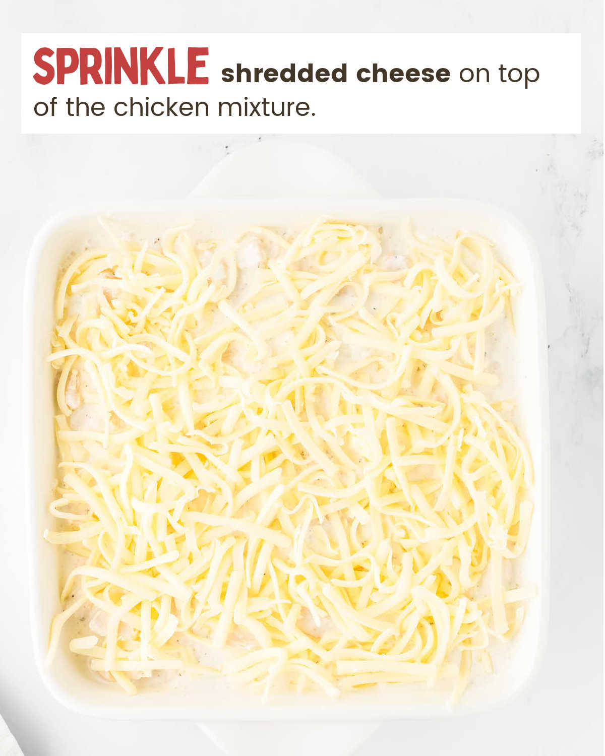 Topping Million Dollar Chicken Casserole with cheese.