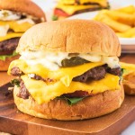 Closeup of a Smash Burger on a wooden plate.