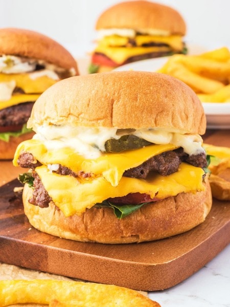 Closeup of a Smash Burger on a wooden plate.