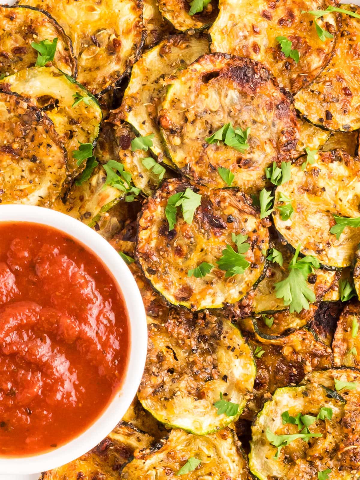 Top down view of Air Fryer Zucchini Chips served with a side of Marinara. 
