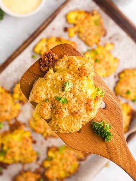 Parmesan Crusted Potatoes on a wooden spatula.