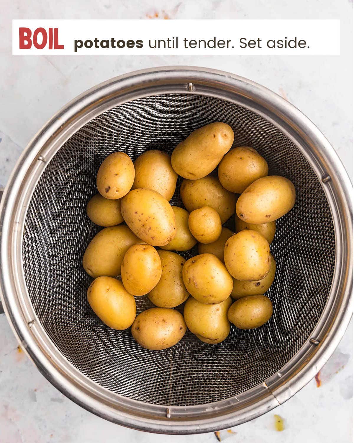Boiled potatoes in a colander for Parmesan Crusted Potatoes.