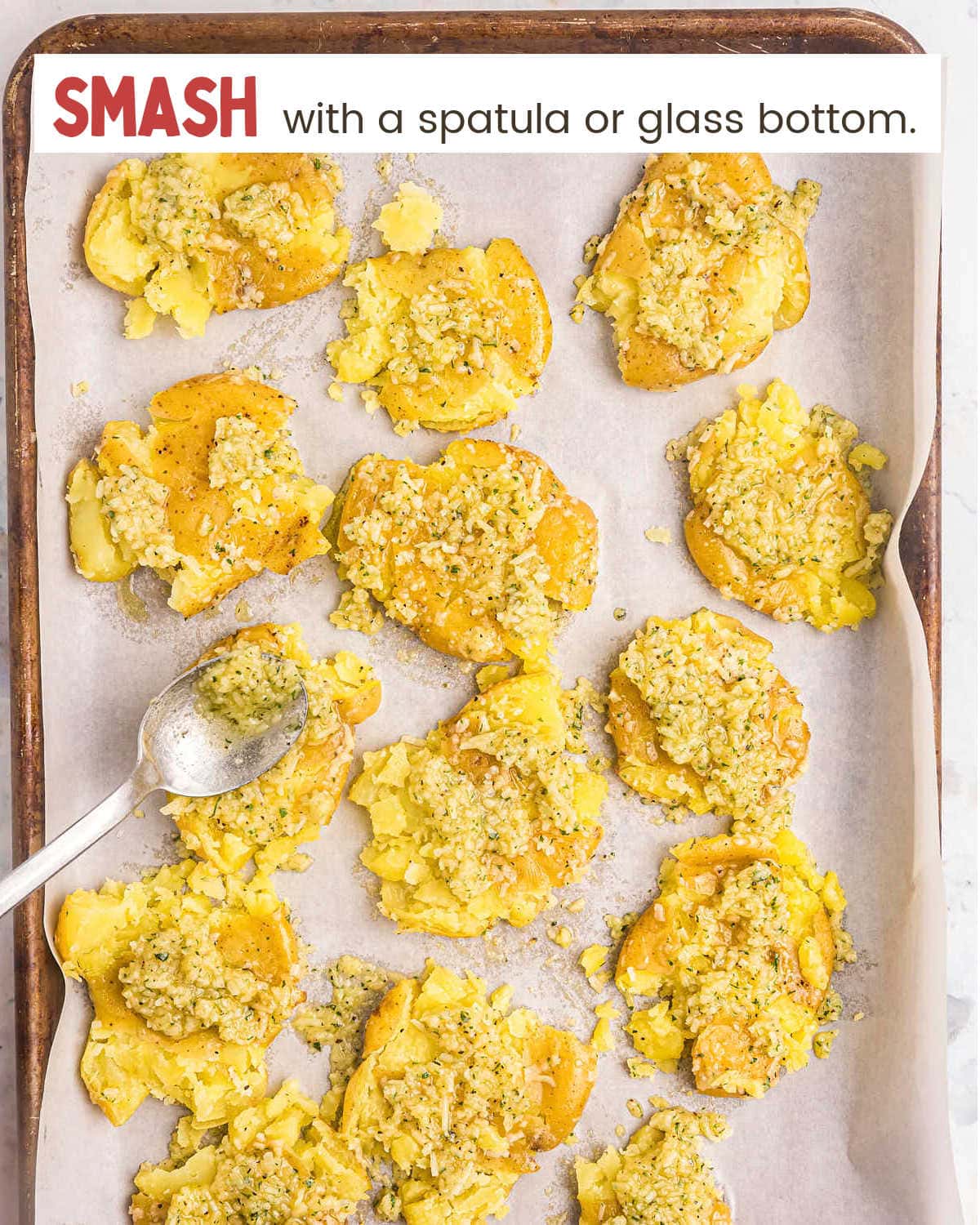 Smashing potatoes on baking sheet for Parmesan Crusted Potatoes.