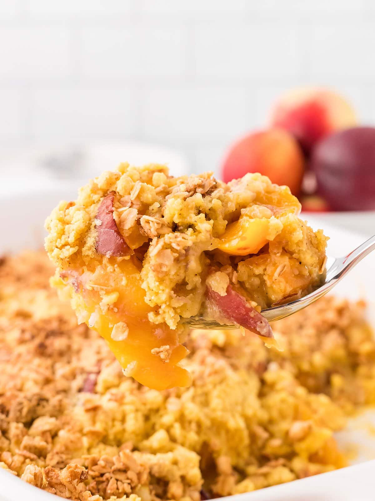 A serving spoon filled with Peach Cobbler Dump Cake.