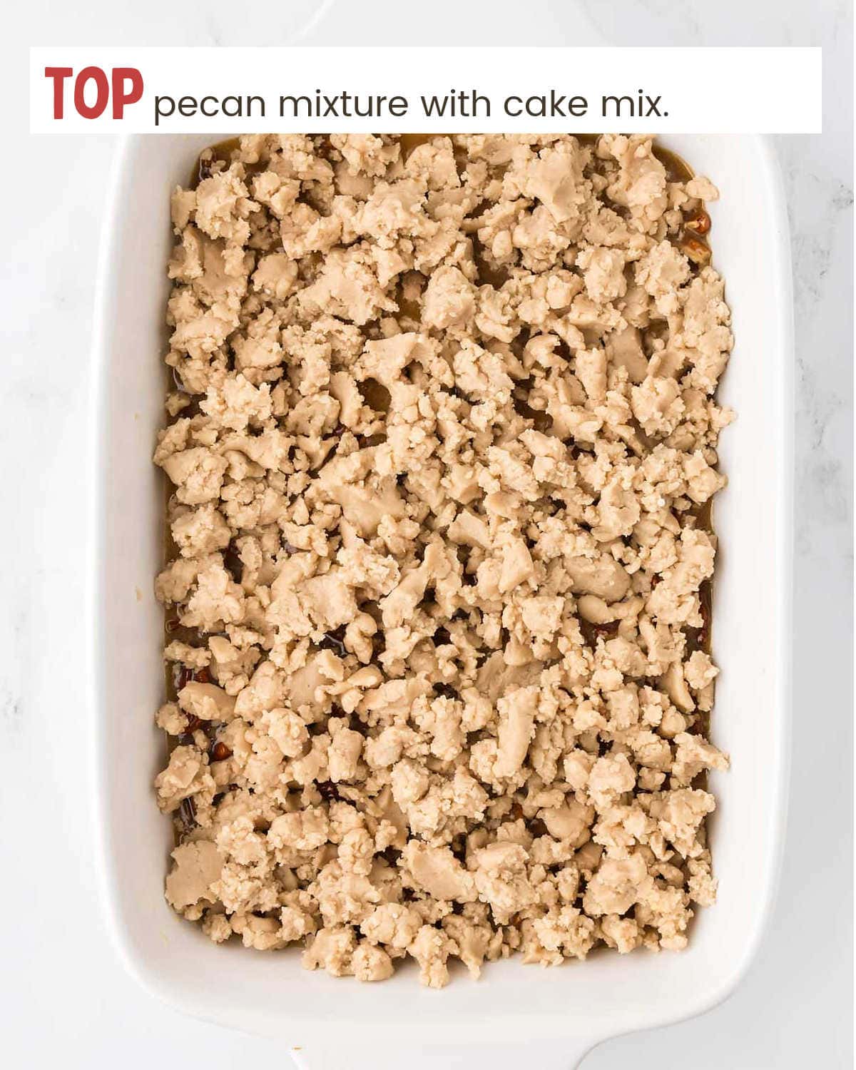 Cake mix and pecan mixture in baking dish for Pecan Pie Dump Cake.
