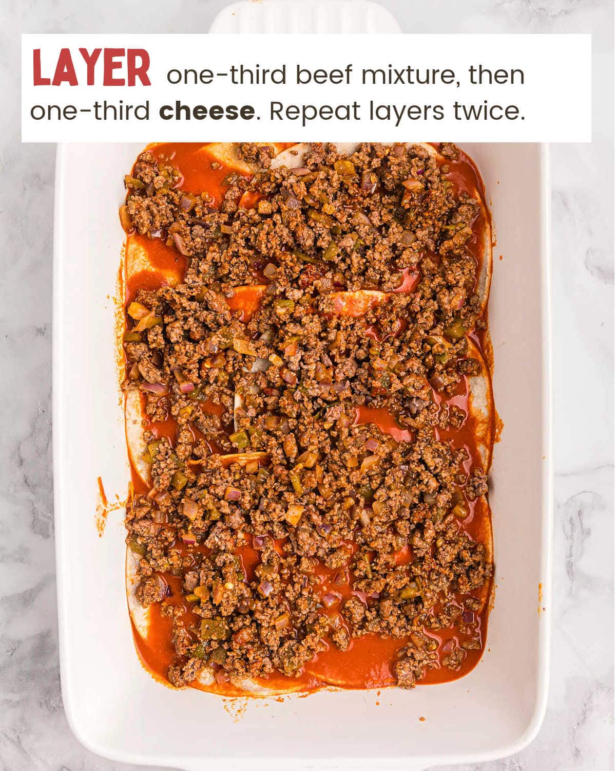 Layering ground beef for a Beef Enchilada Casserole.