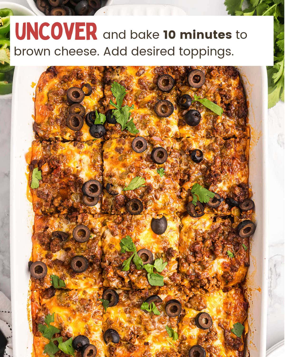 Garnishing baked Beef Enchilada Casserole with olives and cilantro.