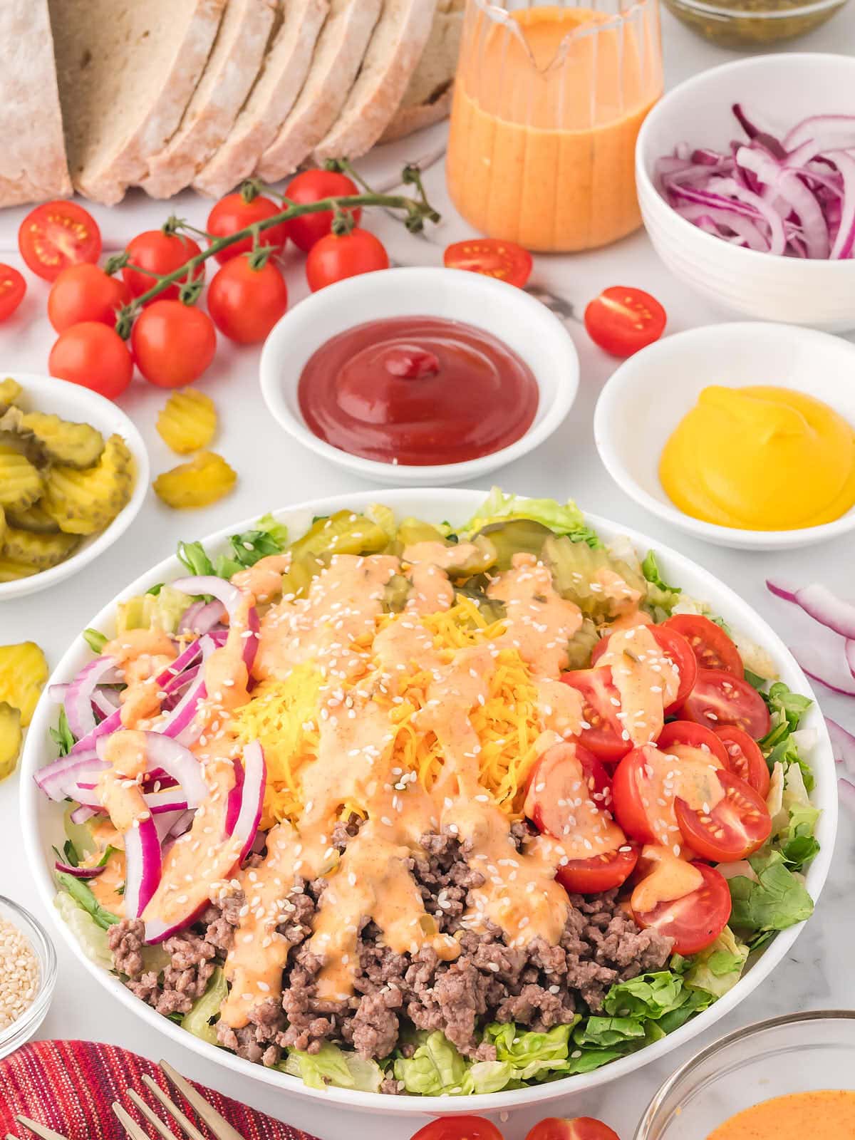Big Mac Salad in a white bowl drizzled with dressing. 
