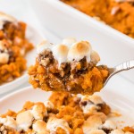 A spoonful of freshly baked Sweet Potato Casserole topped with gooey marshmallows.