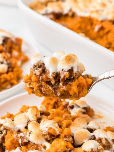 A spoonful of freshly baked Sweet Potato Casserole topped with gooey marshmallows.