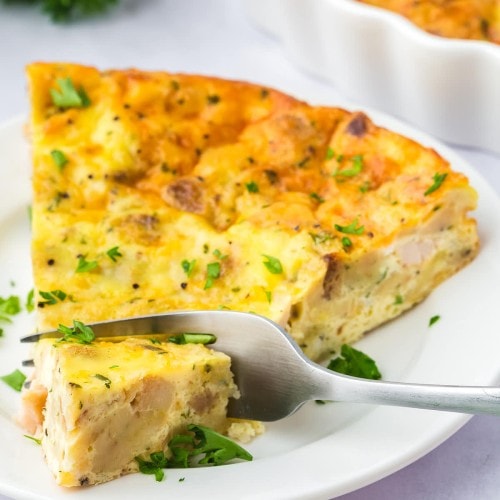 A slice of Thanksgiving Quiche on a white plate.