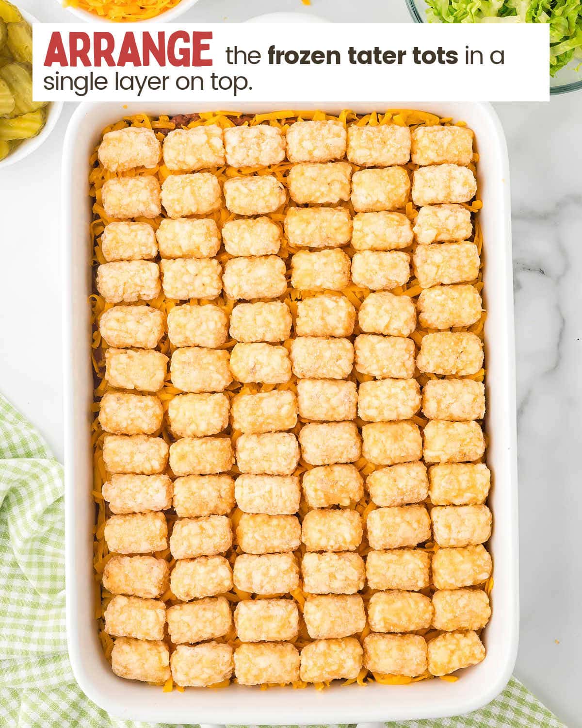 Cooked ground beef casserole topped with frozen tater tots.